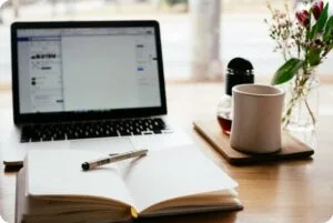 CMA 시험 파트 1 공부법: Part 1 시험 완전 정복 전략 6 a notebook and a laptop on a table next to a cup of coffee